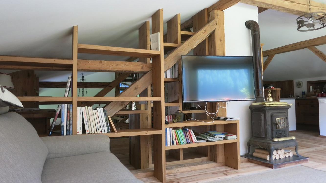 Wohnraum mit Holzregal und Ofen
